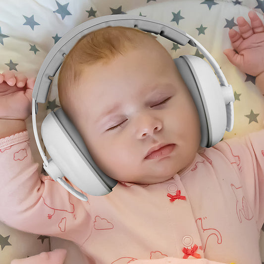 Baby asleep wearing Cubbie ear defenders with the elastic headband