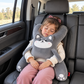 Girl asleep in a car seat with her head on the Grey Husky Kids Comfort Travel Pillow
