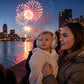 Baby wearing grey ear defenders while the family watches fireworks