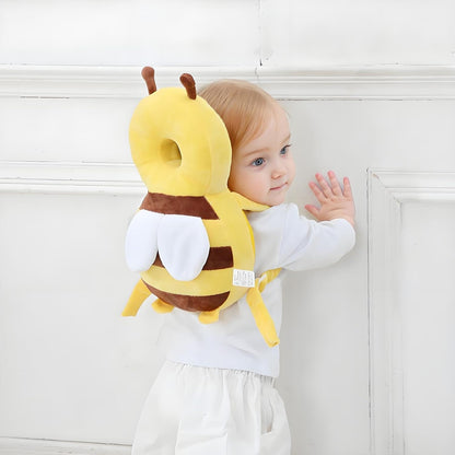 Toddler standing at a wall wearing the bee head protector backpack