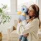 Mother hugging her toddler who wears the blue dragon head protector