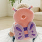 Toddler sitting on a play mat wearing the butterfly head protector backpack