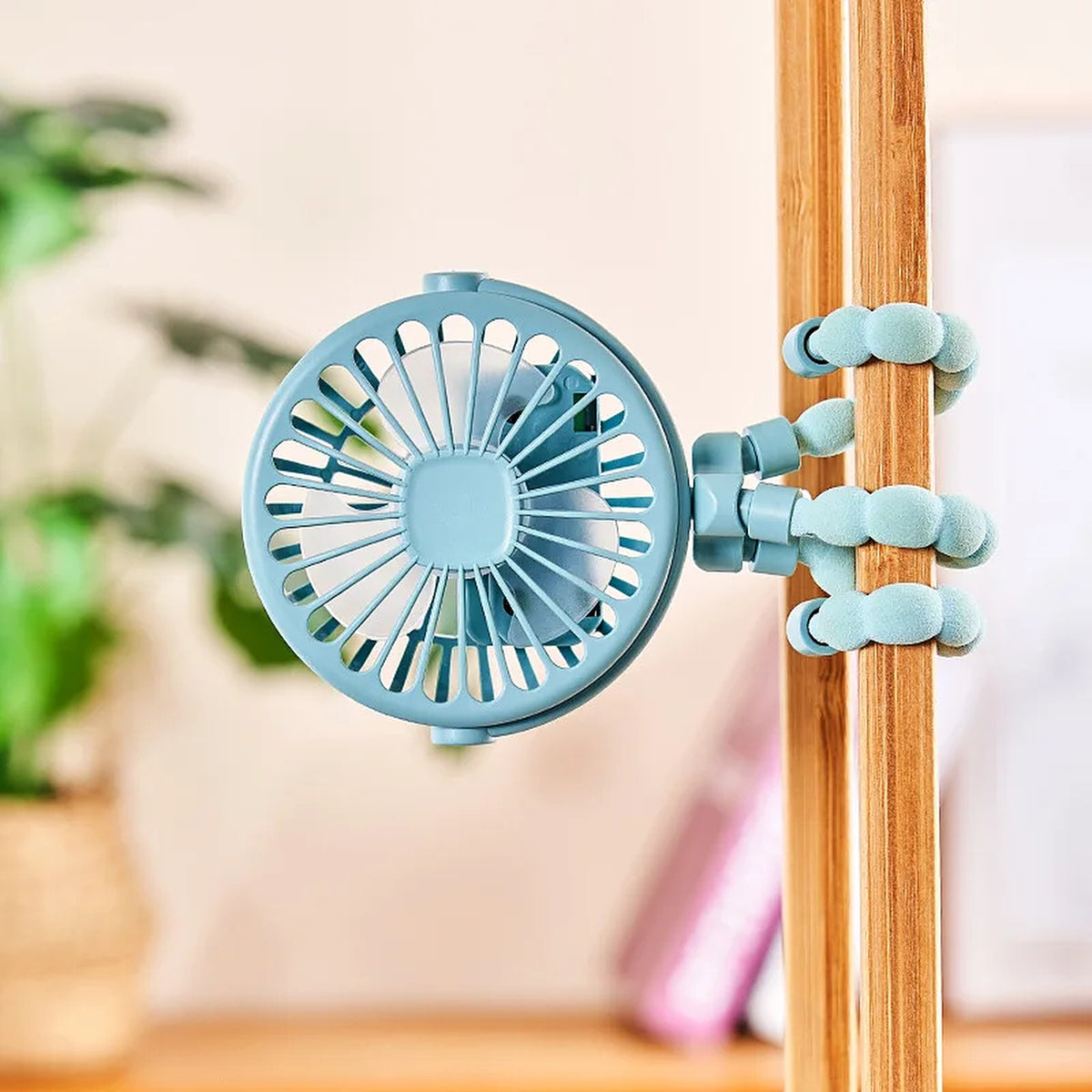 Blue pram fan with its bendy legs wrapped round a wooden pole