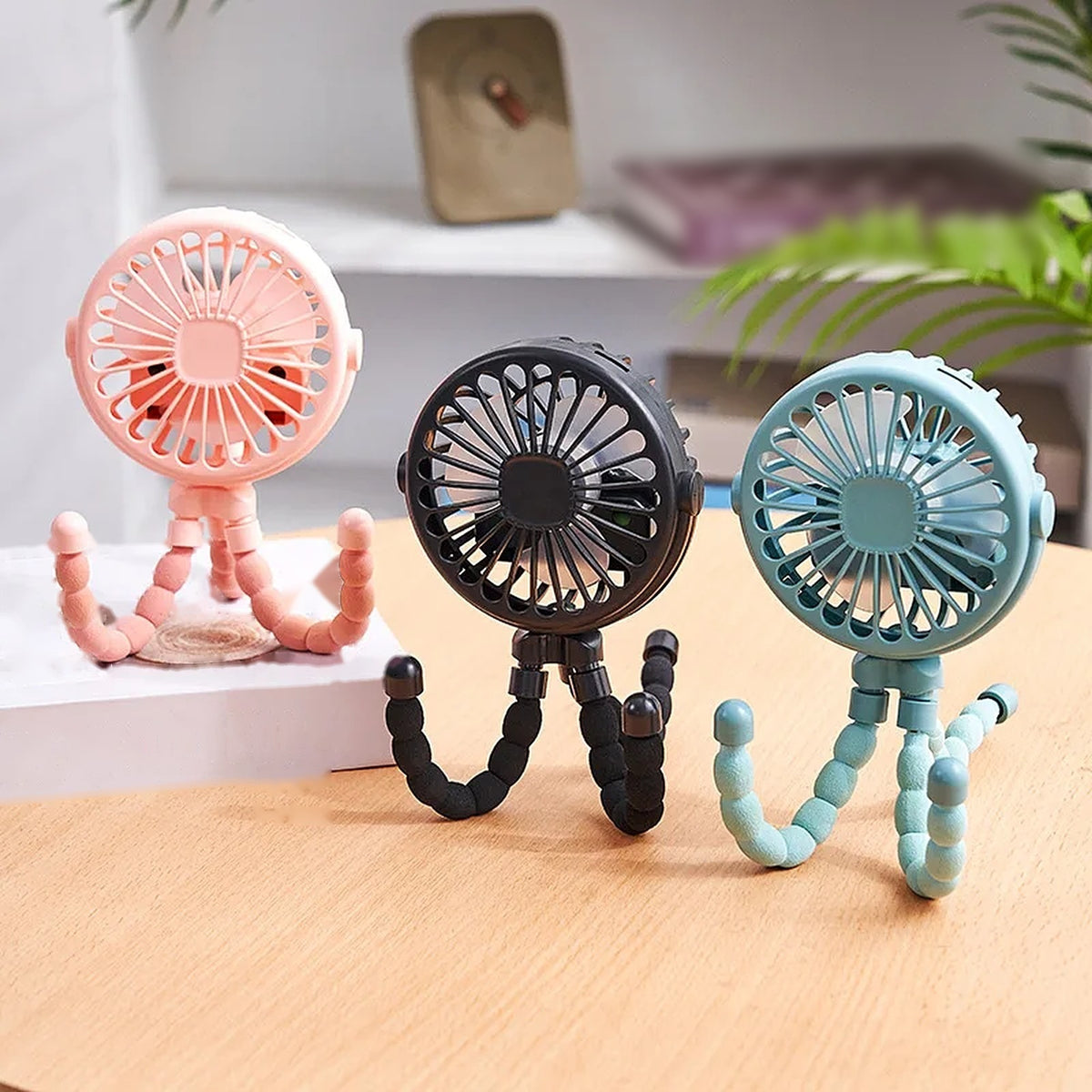 Pink, black and blue pram fans standing on a table