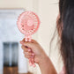 Girl holding the pink pram fan to show its palm size