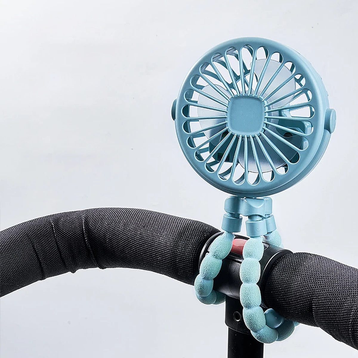 Blue pram fan clipped to a pushchair handlebar